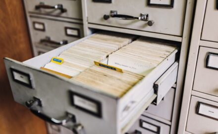 Close-up of an open drawer of a filing cabinet, full of typewritten documents, and tab separaters.
